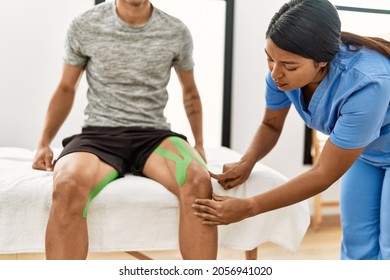 Young Latin Physioterapist Woman Make Knee Rehab Treatment To Hispanic Man At The Clinic.