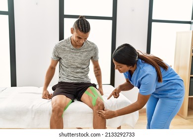 Young Latin Physioterapist Woman Make Knee Rehab Treatment To Hispanic Man At The Clinic.