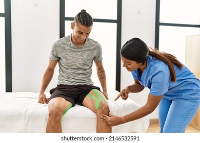 Young Latin Physioterapist Woman Make Knee Rehab Treatment To Hispanic Man At The Clinic.