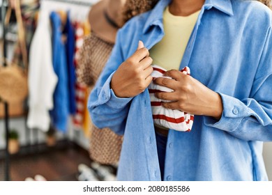 Young latin robber woman stealing handbag at clothing store.