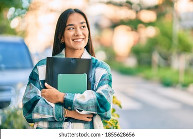 Young Latin Student Girl Smiling Happy Holding Folder At The City.