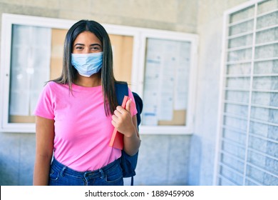 Young Latin Student Girl Wearing Medical Mask Holding Book At University Campus