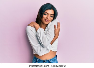 Young latin transsexual transgender woman wearing casual clothes hugging oneself happy and positive, smiling confident. self love and self care 