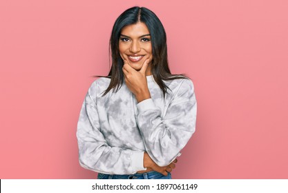 Young latin transsexual transgender woman wearing casual clothes looking confident at the camera smiling with crossed arms and hand raised on chin. thinking positive. 