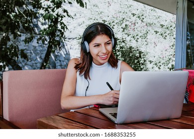 Young Latin Woman Alone In Home Office Or Studing Online With Laptop, Mexican Girl In Mexico Studying At Home