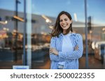 Young latin woman in casual clothing in the street looking at camera, during early morning. Portrait of healthy girl enjoying during sunset. Mindful multiethnic woman enjoy 