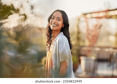 Young latin woman in casual clothing in the garden looking at camera, during early morning. Portrait of healthy mexican girl enjoying nature during sunset. Mindful multiethnic woman enjoy morning. - Powered by Shutterstock