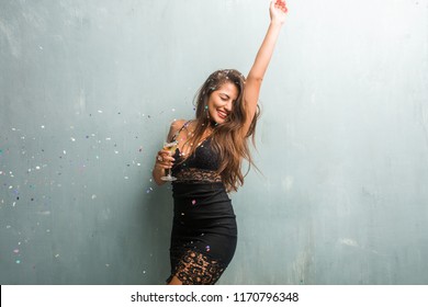 Young Latin Woman Celebrating New Year Or An Event. Excited And Happy, Holding A Champagne Bottle And A Cup.