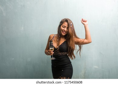 Young Latin Woman Celebrating New Year Or An Event. Excited And Happy, Holding A Champagne Bottle And A Cup.