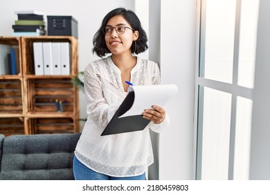 Young Latin Woman Having Psychology Session Writing On Clipboard At Psychology Center