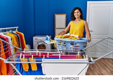 Young Latin Woman Holding Basket Hanging Clothes On Clothesline At Laundry Room