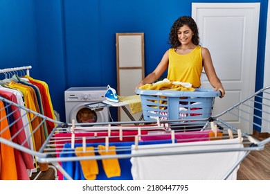 Young Latin Woman Holding Basket Hanging Clothes On Clothesline At Laundry Room