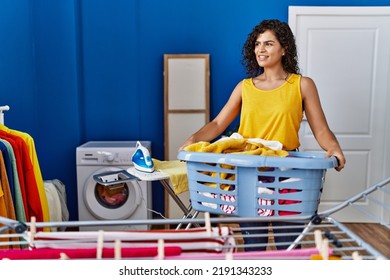 Young Latin Woman Holding Basket Hanging Clothes On Clothesline At Laundry Room