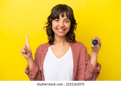 Young latin woman holding compass isolated on yellow background pointing up a great idea - Powered by Shutterstock