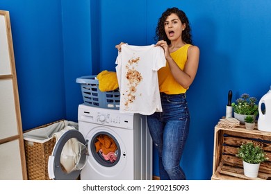 Young Latin Woman Holding Dirty T Shirt At Laundry Room