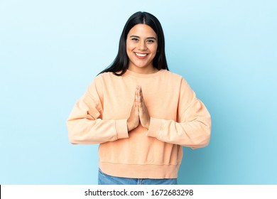 Young latin woman woman isolated on blue background keeps palm together. Person asks for something - Shutterstock ID 1672683298