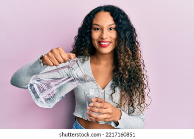 Young Latin Woman Pouring Water Smiling With A Happy And Cool Smile On Face. Showing Teeth. 