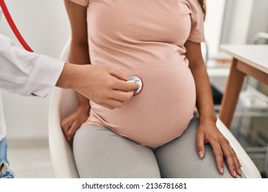 Young Latin Woman Pregnant And Doctor Auscultating Belly At Clinic