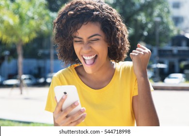 Young Latin Woman Receiving Good News By Phone