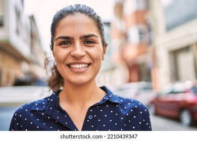 Young latin woman smiling confident standing at street - Shutterstock ID 2210439347