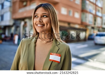 Young latin woman smiling confident wearing sticker at street