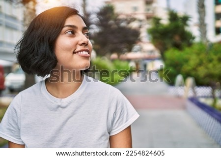 Young latin woman smiling confident standing at street