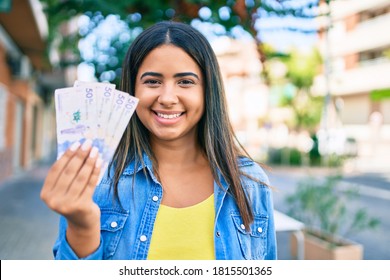 Young Latin Woman Smiling Happy Holding Colombian Pesos At City.