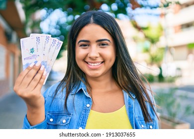 Young Latin Woman Smiling Happy Holding Colombian Pesos At City.