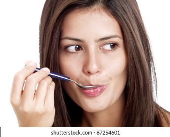 Young Latin Woman With Spoon In Mouth On White Background.