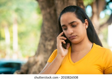 Young Latin Woman Talking On The Phone Very Sad
