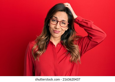 Young latin woman wearing casual clothes and glasses confuse and wonder about question. uncertain with doubt, thinking with hand on head. pensive concept.  - Shutterstock ID 2163620437