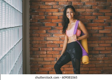 Young Latin Woman In A Yoga Studio After A Class. Loose Hair, Sweaty And Happy.