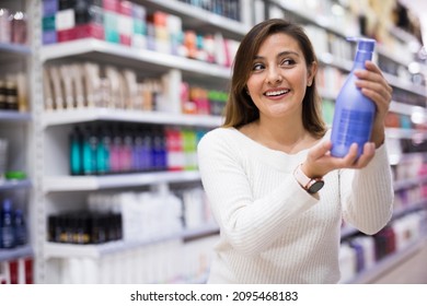 Young Latina choosing haircare cosmetics in specialized boutique - Shutterstock ID 2095468183