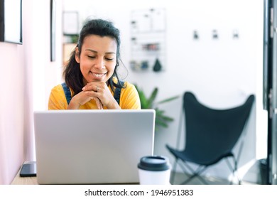 Young Latina Woman Using A Laptop At Her Workplace. Space For Text.