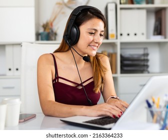 Young Latina Woman Wearing Headphones Working In Modern Office