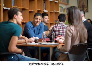 Young Latino American Student Socialize With Friends After Class In Library