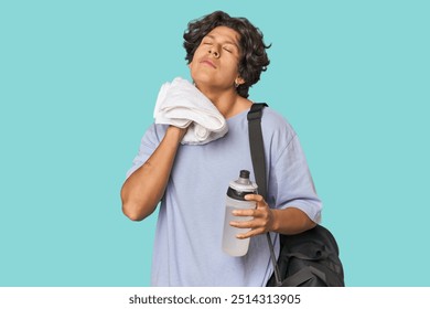 Young Latino athlete wiping sweat in studio - Powered by Shutterstock