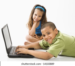 Young Latino Boy Using Laptop Computer While Girl Watches.