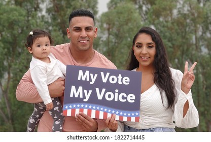 A Young Latino Family Holds Up A Voting Sign