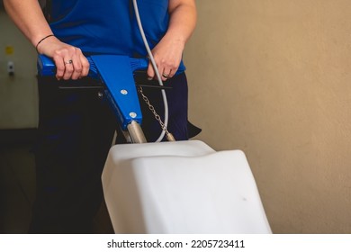 Young Latino Janitorial Worker Lady In Blue Uniform Cleaning In Building With Industrial Vacuum Cleaner