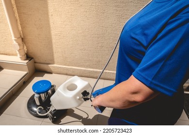 Young Latino Janitorial Worker Lady In Blue Uniform Cleaning In Building With Industrial Vacuum Cleaner