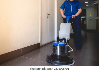 Young Latino Janitorial Worker Lady In Blue Uniform Cleaning In Building With Industrial Vacuum Cleaner