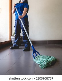 Young Latino Janitorial Worker Lady In Blue Uniform Cleaning In Building With Industrial Vacuum Cleaner