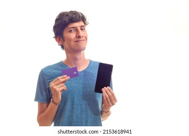 Young Latino Man Happy Shopping On His Cell Phone With His Digital Credit Card. In Flatlay.