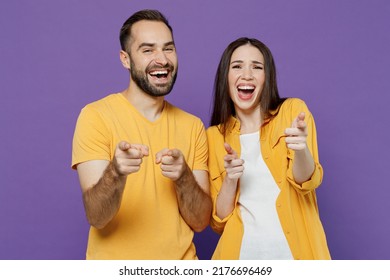 Young Laughing Happy Joyful Cool Fun Couple Two Friends Family Man Woman Together In Yellow Casual Clothes Point Index Finger Camera On You Joking Isolated On Plain Violet Background Studio Portrait