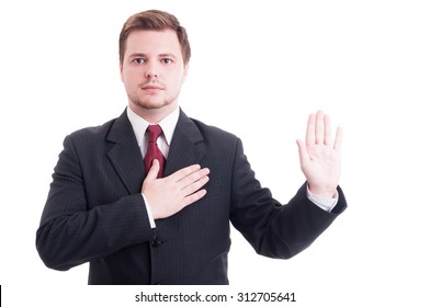 Young lawyer making oath or swearing gesture with one hand on the heart and the other one up as pledge concept
