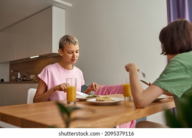 Young lesbian caucasian couple having breakfast at table at home. Concept of domestic lifestyle. Idea of homosexual relationship and spending time together. Modern spacious apartment. Sunny morning - Powered by Shutterstock