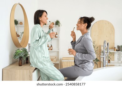 Young lesbian couple brushing teeth in bathroom - Powered by Shutterstock