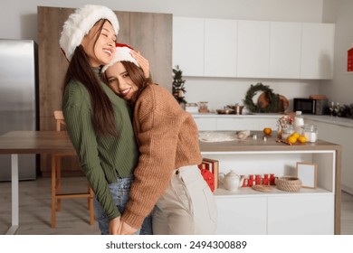 Young lesbian couple dancing in kitchen on Christmas eve - Powered by Shutterstock