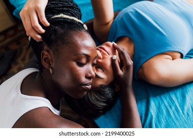 Young lesbian couple with eyes closed resting at home स्टॉक फ़ोटो